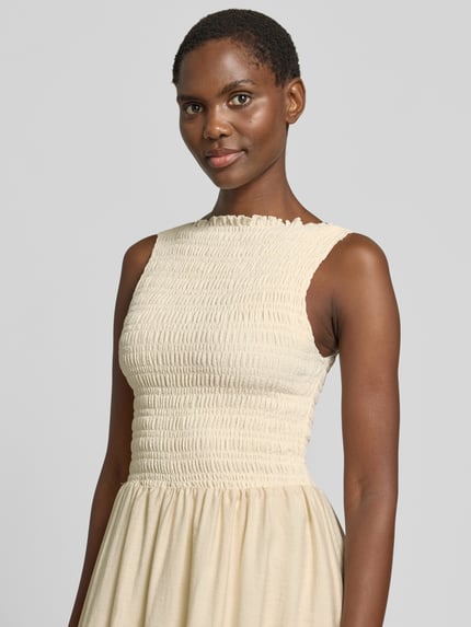 Frauenmodel trägt Midikleid mit Smok-Details von Jake*s Casual, cremefarben, Material-Mix mit Stretch-Anteil, A-Linie, Nahaufnahme Oberkörper.