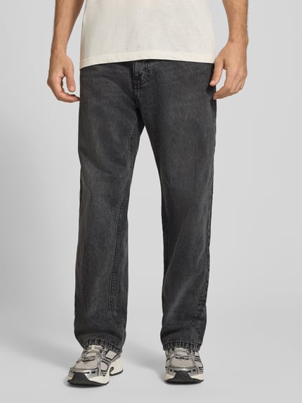 Männermodel trägt Baggy Jeans in Grau im klassischen 5-Pocket-Look von REVIEW, reine Baumwolle, lockerer Schnitt, Nahaufnahme Oberkörper bis Schuhe.
