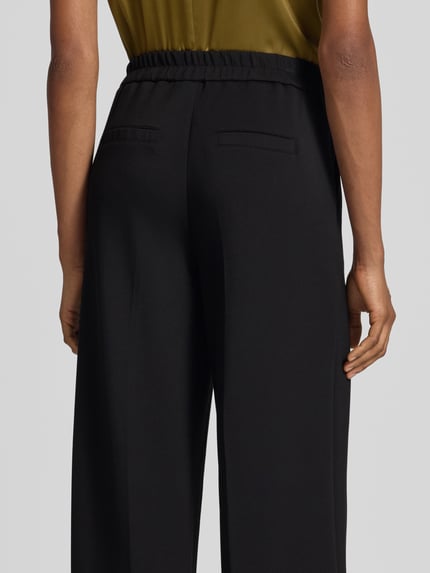Vrouwenmodel draagt zwarte Regular fit wijdte broek uit modalmix model 'BELLIS' van VERO MODA, Dames wijdte broek, rugaanzicht detailopname.