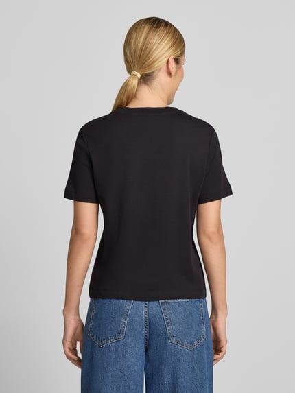 Frauenmodel trägt Regular Fit T-Shirt aus reiner Baumwolle von s.Oliver RED LABEL, schwarz, kombiniert mit blauer Jeans, Ganzkörperansicht Rückansicht.