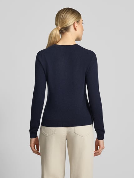 Frauenmodel trägt Slim Fit Strickpullover aus reinem Kaschmir von Christian Berg Woman in Dunkelblau, glatte Struktur, Ganzkörperansicht Rückansicht, taillierte Passform, elastische Abschlüsse, Rückenlänge 54 cm, Ärmellänge 65 cm.