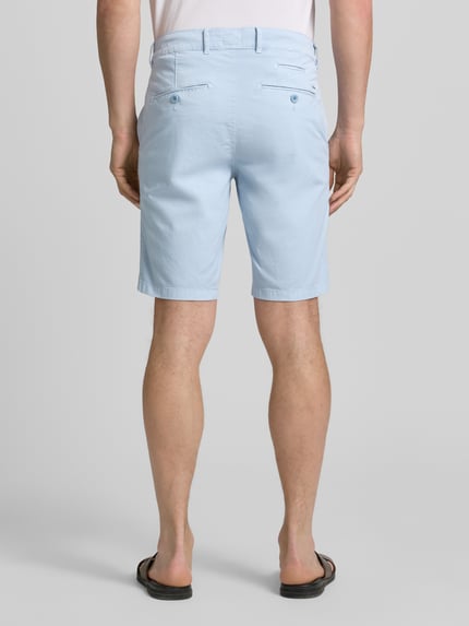 Männermodel trägt hellblaue Regular Fit Bermuda aus Baumwoll-Mix von Brax, glatte Textur, Herren Bermuda, Ganzkörperansicht Rückansicht.