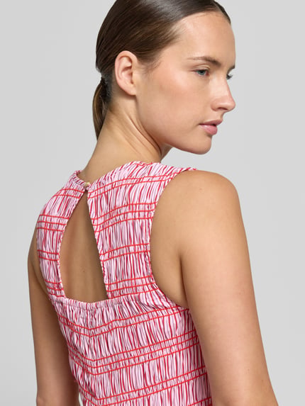 Kobieta nosi A-Linie Freizeitkleid aus reiner Baumwolle od Tommy Hilfiger, wzór w czerwone i białe linie, tekstura gładka, zbliżenie na plecy