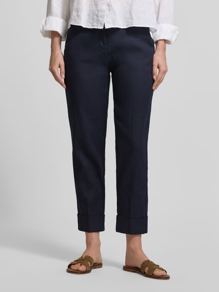 Vrouwenmodel draagt Leinenhose met Baumwoll-Anteil van Cambio, donkerblauw, rechte pijpen, steek- en achterzakken, omslag aan de pijpen, mix van katoen en linnen, verkorte pasvorm, riemlussen, knoop- en ritssluiting, maat 36 bandwijdte 42 cm, binnenbeenlengte 69 cm, model Krystal, full-body frontaal.