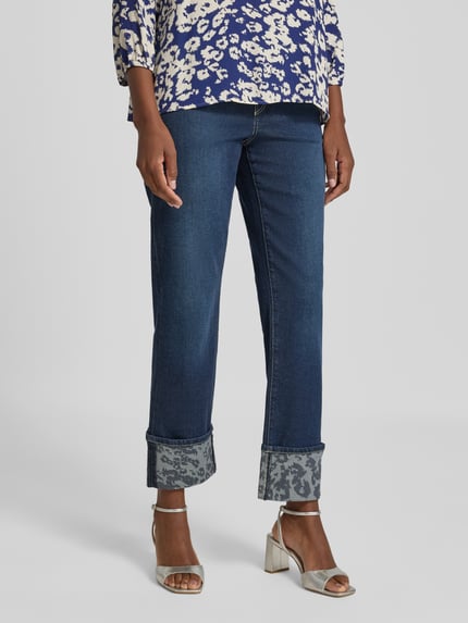 Frauenmodel trägt Feminine Fit Jeans mit Umschlag und Eingrifftaschen von Marc Cain, Baumwoll-Mix mit Lyocell-Anteil, dunkles Blau, Nahaufnahme Unterkörper.
