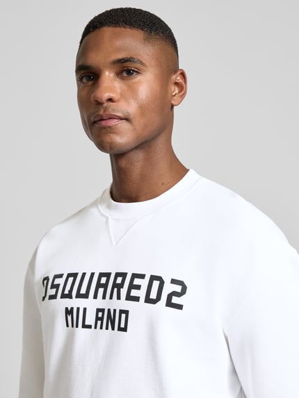 Männermodel trägt Cool Fit Sweatshirt aus reiner Baumwolle von Dsquared2, Weiß mit schwarzem Label-Print, Nahaufnahme Oberkörper.