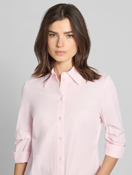 Frauenmodel trägt Hemdbluse mit 3/4-Arm mit Aufschlag von Marc Cain in zartem Rosa, glatte Baumwoll-Viskose-Struktur, Nahaufnahme Oberkörper.