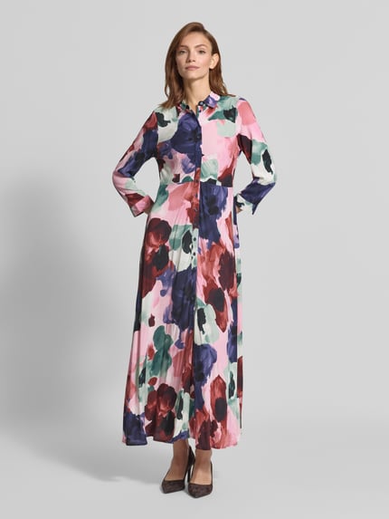 Vrouwenmodel draagt overhemdjurk uit zuiver viscose, getailleerd model, maxi-jurk, Model 'SAVANNA' van YAS, overhemdkraag, knoopsluiting, 3/4-mouw, ruglengte maat S 139 cm, borstwijdte maat S 45 cm, mouwlengte maat S 49 cm, kleurrijke bloemenprint, gladde textuur, Ganzkörperansicht van voren.