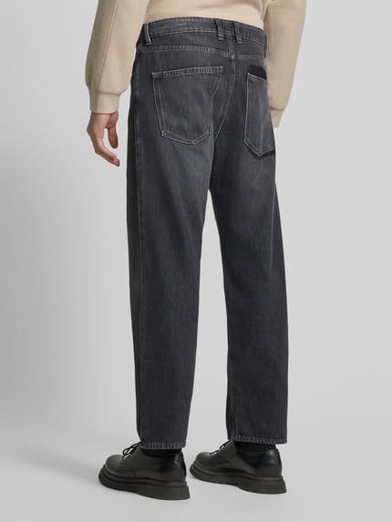 Männermodel trägt Baggy Fit Jeans aus reiner Baumwolle von DRYKORN, dunkelgrauer Denim, 5-Pocket-Design, Ganzkörperansicht Rückansicht.