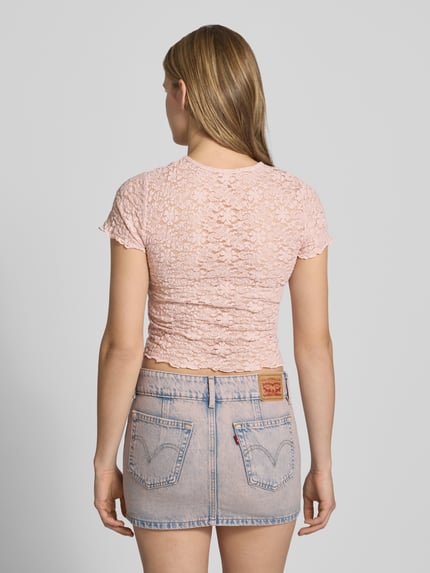 Vrouwenmodel draagt Slim Fit T-Shirt aus Spitze Modell 'FAITH' van Only, lichtroze, effen, kanten patroon, korte mouw, frill, ronde hals, detailopname rugaanzicht.