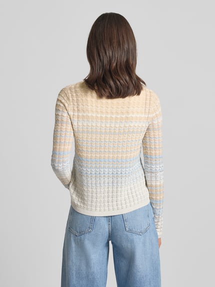 Frauenmodel trägt Strickjacke aus Viskose-Mix Modell 'ROSALYN' von Guess mit beige-blauen Farbverlauf, gerader Schnitt, Rückansicht.