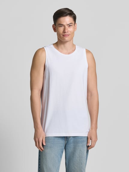 Männermodel trägt Relaxed Fit Tank Top aus Reine Baumwolle von Armedangels in Optik: Unifarben, Rundhals-Ausschnitt, breite Träger, Ganzkörperansicht von vorne.