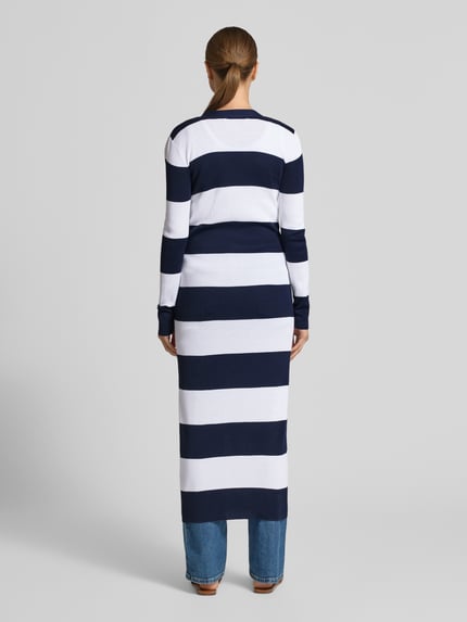 Frauenmodel trägt Longcardigan mit Knopfleiste von Lauren Ralph Lauren im Baumwoll-Viskose-Mix, taillierter Schnitt, breite weiße und dunkelblaue Querstreifen, gerippter V-Ausschnitt, Eingrifftaschen, Rückenlänge bei Größe S 125 cm, Ärmellänge 62 cm, Ganzkörperansicht Rückansicht.
