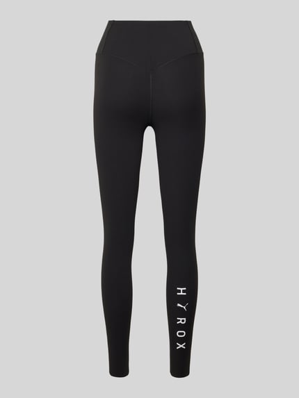 Produktfoto, czarne legginsy z mieszanki materiałów z dodatkiem streczu, dopasowany krój, elastyczny pas, logo, Model 'PUMA x HYROX SHAPELUXE' od PUMA