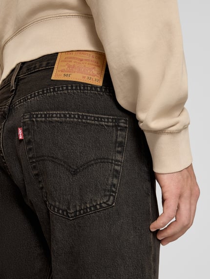 Mężczyzna nosi Wide & Loose Fit Jeans aus reiner Baumwolle Modell '501®' od Levi's®, czarny bawełniany denim, detal tylnej kieszeni, Herren Wide & Loose Fit Jeans von Levi's®, detalaufnahme.