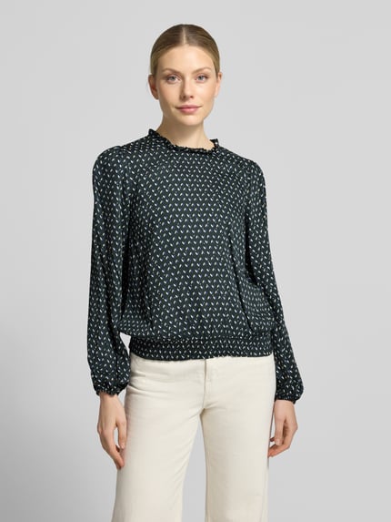Vrouwenmodel draagt Bluse aus Viskose mit Rundhalsausschnitt und Rüschen van MORE, zwarte blouse met wit patroon, zuiver viscose, straight fit, ronde hals met ruches, elastische boordjes, ruglengte maat 36: 52 cm, mouwlengte maat 36: 63 cm, Ganzkörperaanzicht van voren.