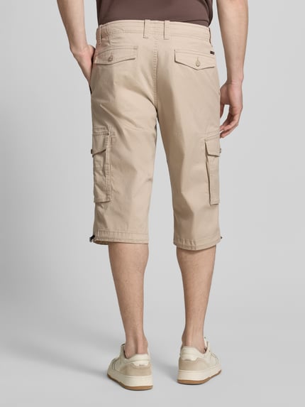 Męski model nosi Capri Cargo Pants mit Pattentaschen von bugatti, mieszanka bawełny, krój straight fit, widok całej sylwetki z tyłu.
