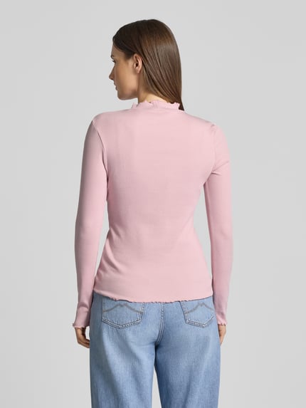 Frauenmodel trägt Slim Fit Langarmshirt aus Baumwoll-Mix von Tom Tailor Denim, unifarben in Rosa, Feinripp, Frill-Abschlüsse, Ganzkörperansicht Rückansicht.