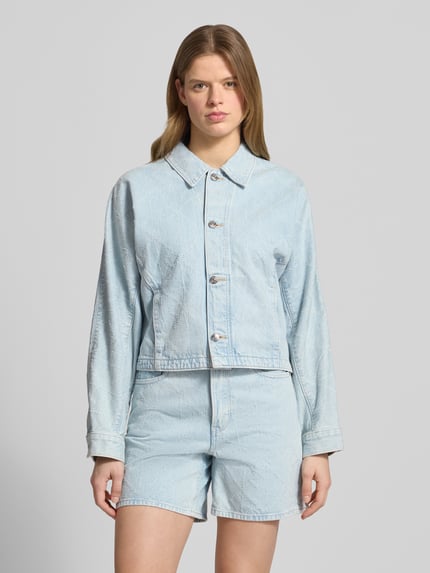 Modelka prezentuje kurtkę jeansową w kolorze jasnoniebieskim, prosty krój, bawełna, model 'DOLEMAN TRUCKER' od Calvin Klein Jeans, wpuszczane kieszenie, listwa guzikowa, kołnierzyk typu kent, szerokość ramion w rozmiarze S: 40 cm, szerokość klatki piersiowej w rozmiarze S: 58 cm, długość rękawów w rozmiarze S: 61 cm, długość tyłu w rozmiarze S: 52 cm, całkowity widok z przodu
