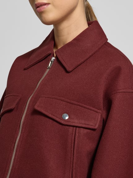 Vrouwenmodel draagt Regular Fit Hemdjacke met Reißverschluss Modell 'FORTUNEFREJ' van Vero Moda, unikleurig, filz, detailopname bovenlichaam.