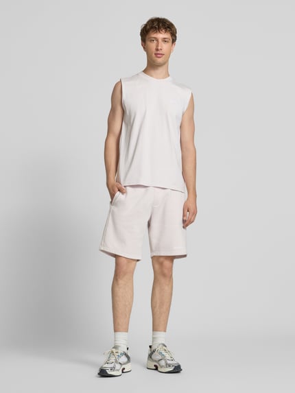 Männermodel trägt Tanktop mit Label-Stitching und Rundhalsausschnitt von Pegador aus Reine Baumwolle im Relaxed-Fit, Ganzkörperansicht von vorne. Rückenlänge bei Größe M: 66 cm.