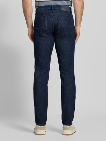 Männermodel trägt dunkelblaue jeansy Regular Fit Jeans aus mieszanka bawełny i kaszmiru Modell 'Cadiz' von Brax, Herren Straight Jeans, Ganzkörperansicht Rückansicht