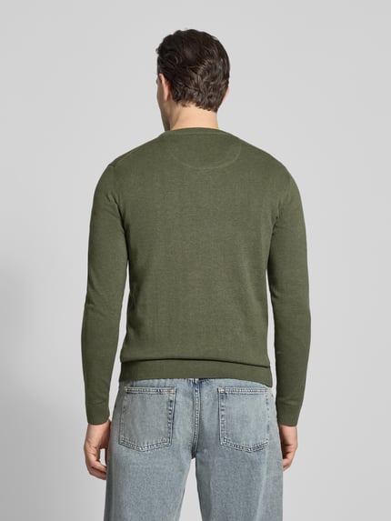 Männermodel trägt Regular Fit Strickpullover aus reiner Baumwolle von Tom Tailor in unifarbenem Melange-Grün, gerippte Bündchen, Ganzkörperansicht Rückansicht.