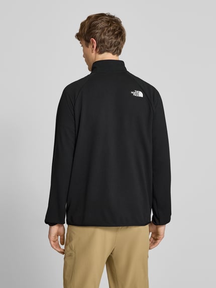 Männermodel trägt Jacke mit Raglanärmeln und Logo-Print Modell 'PACKABLE KECHA' von The North Face, Schwarz, Material-Mix mit Stretch-Anteil, Gerader-Schnitt, Stehkragen, Reißverschluss, Rückenlänge 68 cm, Ärmellänge 72 cm, Ganzkörperansicht Rückansicht.