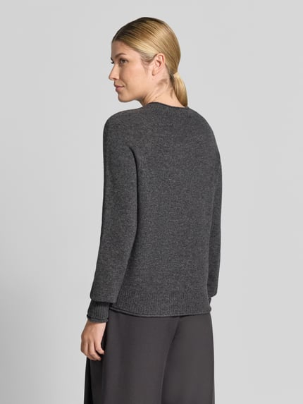 Frauenmodel trägt Regular Fit Pullover aus reiner Wolle von Lacoste in Dunkelgrau, weiche Textur, Damen Pullover, Ganzkörperansicht Rückansicht.