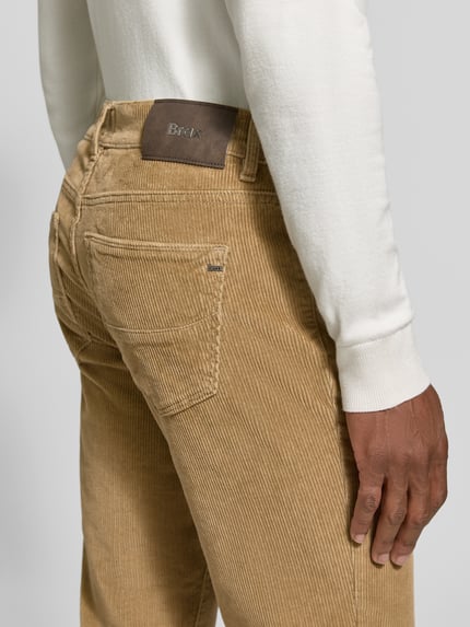 Männermodel trägt beigefarbene Straight Fit Cordhose aus Baumwoll-Mix Modell 'Mythos Flex Cord' von Brax, Detailaufnahme Rückansicht, Herren Cordhose von Brax.