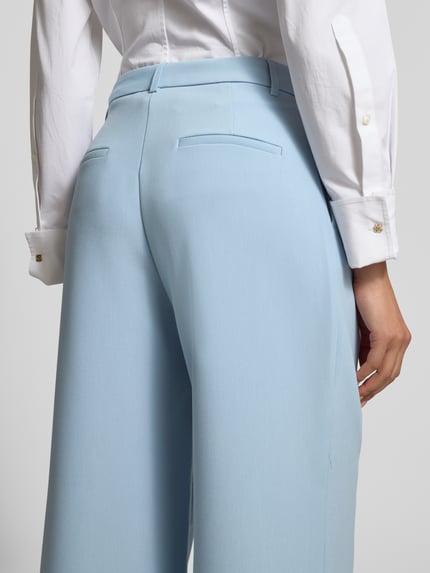 Frauenmodel trägt Wide Fit Stoffhose mit Viskose-Anteil von Jake*s Collection in Hellblau mit Gesäßtaschen, Elastischer-Material-Mix, Ganzkörperansicht Rückansicht.