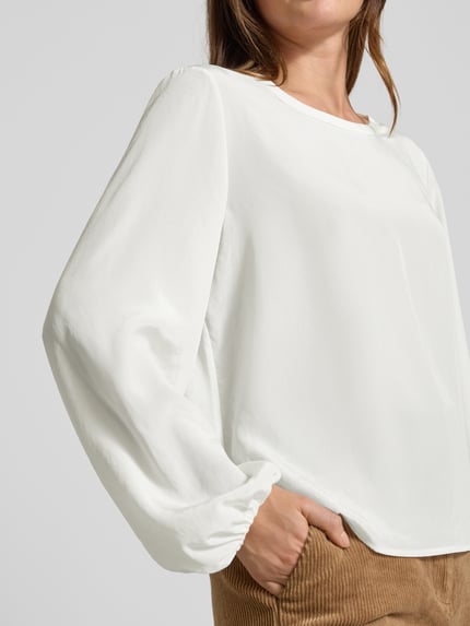 Vrouwenmodel draagt Regular Fit Blouse in semi-transparant design van Luisa Cerano, ronde hals, met lange mouwen, semi-transparante look, ruglengte maat 36: 57 cm, mouwlengte maat 36: 65 cm, detailopname bovenlichaam.