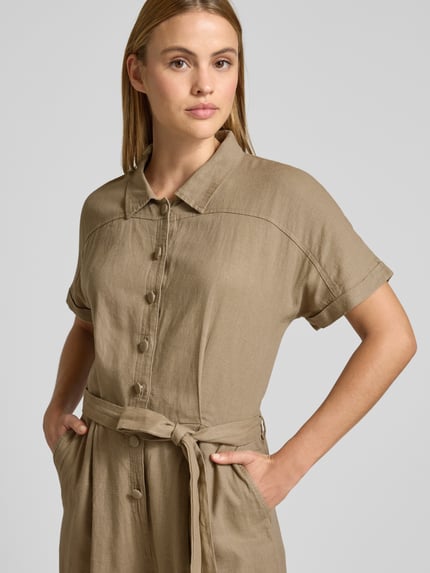 Vrouwenmodel draagt Jumpsuit uit linnenmix met strikriem model 'LINNO' van ICHI in beige, knoopsluiting, getailleerde fit, nahaufnahme bovenlichaam.