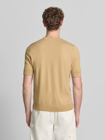 Męski model nosi Slim Fit T-Shirt aus Feinstrick Modell 'SAN CARL-CV' od HUGO w kolorze beżowym, gładka faktura, widok całej sylwetki od tyłu.