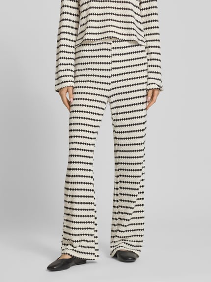 Vrouwenmodel draagt Loose Fit Stoffhose mit Baumwoll-Anteil Modell 'EVA LIFE' van Only, zwart-wit all-over patroon, wijde pijpen, elastische tailleband, gebreide structuur, katoenmix, voorkant volledige lichaamsopname.