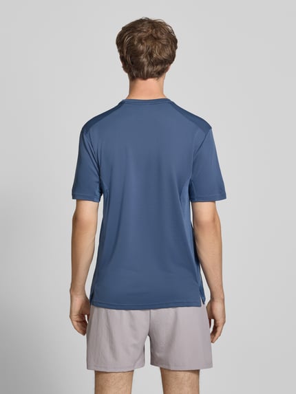 Männermodel trägt Regular Fit T-Shirt mit Logo-Print Modell 'TECH APP TEE' von adidas Training in Blau, Ganzkörperansicht Rückansicht.