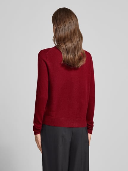 Frauenmodel trägt Strickjacke aus reinem Kaschmir mit durchgängiger Knopfleiste von Christian Berg Woman in Rot, Regular Fit, gerippte Abschlüsse, langärmlig, Ganzkörperansicht Rückansicht.