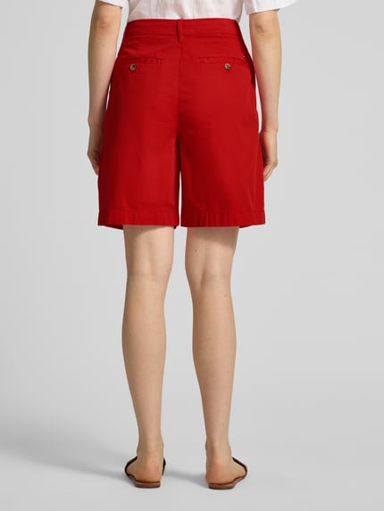 Kobiece modelka nosi Regular Fit Chino-Shorts aus Baumwoll-Lyocell-Mix od Tommy Hilfiger, efekt: jednolity kolor, krój regular fit, wyhaftowane logo, zapięcie na guzik i zamek błyskawiczny, wpuszczane kieszenie, kieszenie z tyłu, mieszanka bawełny i lyocellu; całkowity widok z tyłu.
