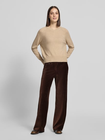 Frauenmodel trägt Regular Fit Cordhose mit Bundfalten Modell 'MAINE' von BRAX, unifarben, Struktur, Cord, seitliche Eingrifftaschen, Ganzkörperansicht von vorne.