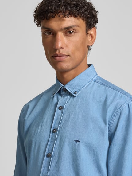 Mannenmodel draagt Regular Fit vrijetijdsoverhemd met button-downkraag van Fynch-Hatton in denimlook, puur katoen, labelstitching, maat M: ruglengte 50 cm, schouderbreedte 47 cm, mouwlengte 66 cm, nahaufnahme bovenlichaam.