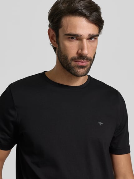 Männermodel trägt T-Shirt mit Logo-Print von Fynch-Hatton in Schwarz, reine Baumwolle, gerader Schnitt, Nahaufnahme Oberkörper.