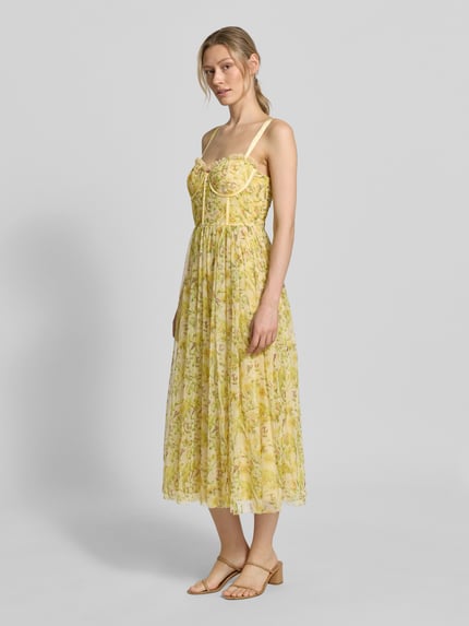 Frauenmodel trägt Cocktailkleid aus Tüll von LACE & BEADS in Gelb mit floralen Mustern, A-Linie, Midikleid, Corsagenkleid, Rückenlänge bei Größe S: 101 cm, Brustweite bei Größe S: 41 cm, Ganzkörperansicht von vorne.