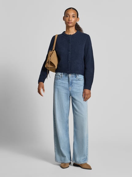 Frauenmodel trägt Strickjacke mit Rundhalsausschnitt und Knopfleiste von Oui in Dunkelblau, kombiniert mit heller Jeans, Material-Mix mit Woll-Anteil, Regular Fit, Ganzkörperansicht von vorne.