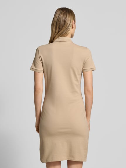 Frauenmodel trägt Slim Fit Polokleid aus Baumwoll-Mix von Lacoste in unifarbener Optik, Mini-Länge, hochgeschlossen, Ganzkörperansicht Rückansicht.