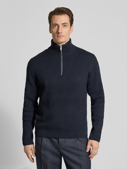 Mannenmodel draagt Strickpullover mit Stehkragen und Reißverschluss van Lindbergh in marineblauw katoenmix riblook, regular fit, vooraanzicht van het hele lichaam. Ruglengte bij maat M: 67 cm, mouwlengte bij maat M: 66 cm.
