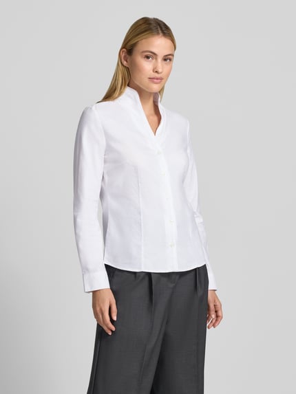 Frauenmodel trägt Regular Fit Hemdbluse aus reiner Baumwolle von Christian Berg Woman, weiß, Stehkragen, Langarm, Ganzkörperansicht von vorne.
