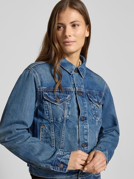 Frauenmodel trägt Regular Fit Jeansjacke aus Baumwoll-Mix von Polo Ralph Lauren in Melange-Optik mit Knopfleiste, Nahaufnahme Oberkörper.