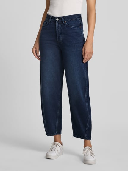 Kobieta modelka nosi ciemnoniebieskie jeansy Loose Fit Barrel Jeans aus Baumwoll-Lyocell-Mix Modell 'BAARLY' od ARMEDANGELS, tekstura gładka, proste formy, Ganzkörperansicht von vorne, damskie jeansy od ARMEDANGELS.