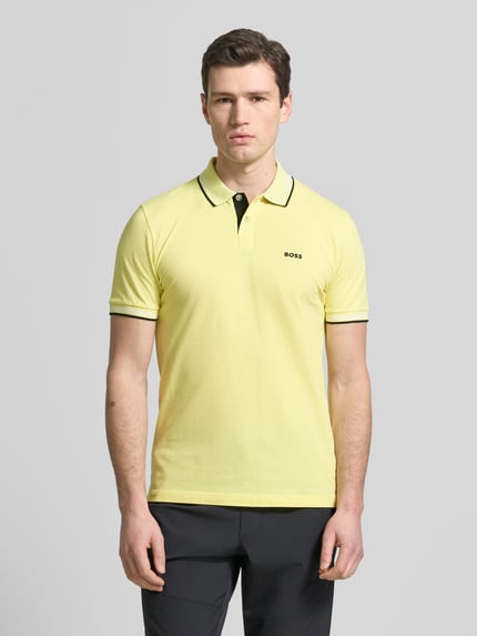Männermodel trägt Slim Fit Poloshirt aus reiner Baumwolle Modell 'PAUL' von BOSS Green, Optik: Unifarben, Ganzkörperansicht von vorne.
