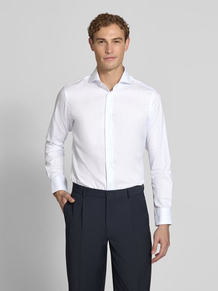 Männermodel trägt Slim Fit Business-Hemd aus reiner Baumwolle von Christian Berg Men, weiß gemustert, Ganzkörperansicht von vorne. Herrenhemd, Haikragen, durchgängige Knopfleiste, langärmelig, leicht strukturierte Oberfläche, Maße laut Kontext.